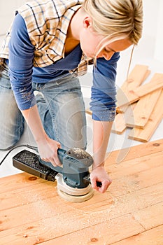 Home improvement - handywoman sanding wooden floor