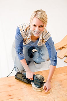 Home improvement - handywoman sanding wooden floor photo