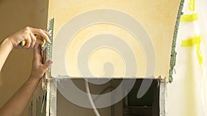 home improvement. a man dismantles a drywall arch in a room