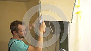 home improvement. a man dismantles a drywall arch in a room