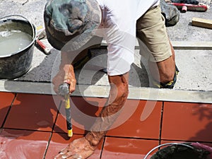 Home improvement, renovation - construction worker tiler is tiling, ceramic tile floor adhesive