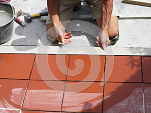 Home improvement, renovation - construction worker tiler is tiling, ceramic tile floor adhesive