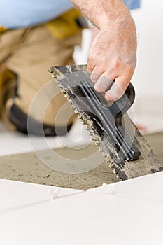 Home improvement, renovation - man laying tile