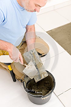 Home improvement, renovation - man laying tile