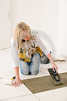 Home improvement, renovation - woman laying tile