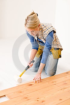 Home improvement - woman installing wooden floor