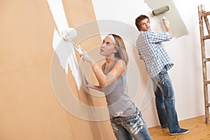 Home improvement: Young couple painting wall