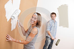 Home improvement: Young couple painting wall photo