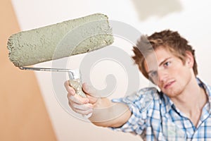 Home improvement: Young man holding paint roller