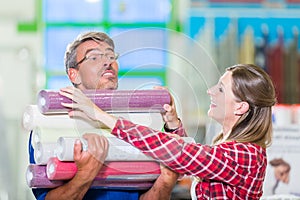 Home improving couple buying wallpapers at hardware store