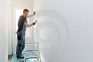 Home interior construction - worker repairing wall