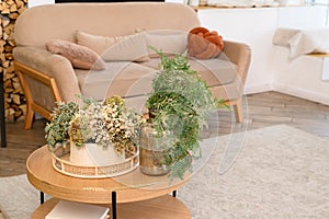 Home interior decor. Coffee table with vases of dried flowers on the background of the sofa