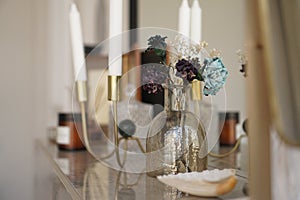 Home interior decor. Glass jar with dried flowers, vase and candle