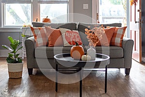 Home interior decorated for fall with orange accent pillows on the couch