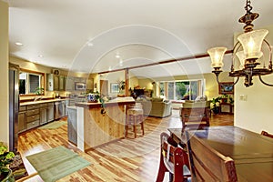 Home interior with hardwood floors and open floor plan showing dining room, kitchen, and living room.