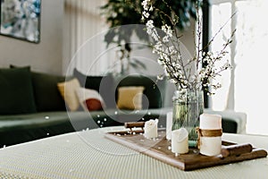 Home interior. Relaxing candles. Apple tree color has flown. Blurred background