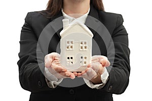 Home investment  with real estate agent showing property concept with crop view of woman in black suit holding a white model house