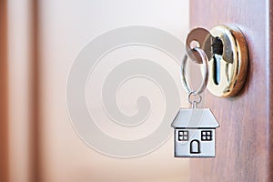 Home key with house keyring in the door keyhole