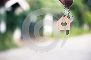 Home key with house keyring giving with blur house background