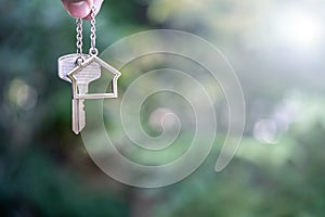 Home key with house keyring giving with blur house background