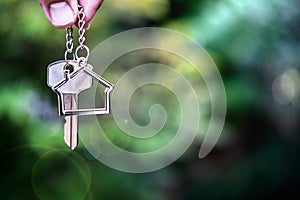 Home key with house keyring giving with blur house background