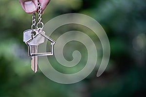 Home key with house keyring giving with blur house background