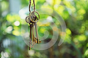 Home key with house keyring hanging with blur garden background