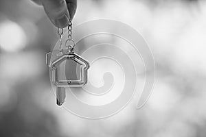 Home key with house keyring hanging with white wall background