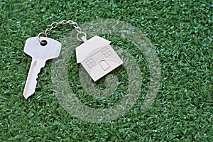 Home key with house keyring on white wood table background, property concept