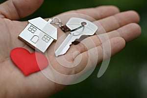 Home key with love house keyring and red mini heart on hand, sweet home giving, concept