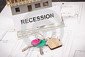 Home keys, dollar and inscription recession on housing plan. House under contruction. Crisis of real estate market. Reduced