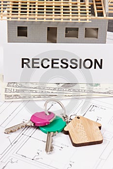 Home keys, dollar and inscription recession on housing plan. House under contruction. Crisis of real estate market. Reduced