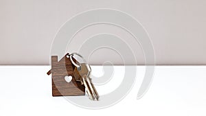 Home keys in a house shape keyring over a table