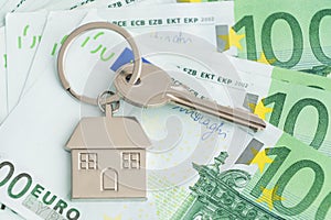 Home keys and a small house on currencies euro background