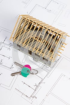 Home keys and small house under construction on electrical drawings, building home concept