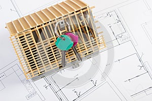 Home keys and small house under construction on electrical drawings, building home concept