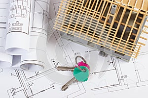 Home keys, small house under construction and electrical drawings, building home concept