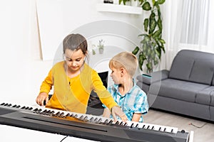 Home lesson on music for kids on the piano. The idea of activities for the child at home during quarantine. Music