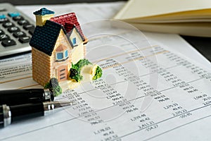 Home loan bank debit statement with house miniature