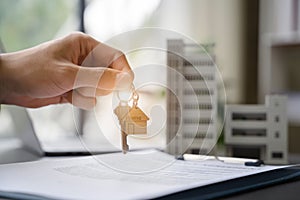 home loan officer gives the house keys to the client after signing a real estate contract with an approved mortgage application