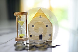 Home loans,saving for a real estate concept,Present by coins,home and hourglass with sunlight effect