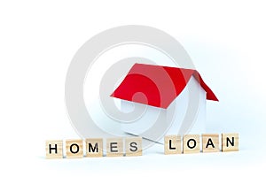 Home loans- word composed fromwooden blocks letters on White background, layout of a house with a red roof. copy space