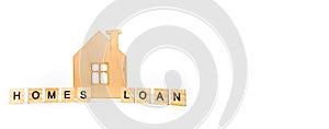 Home loans- word composed fromwooden blocks letters on White background, wooden house symbol. copy space for ad text. Banner