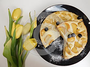 Home made apple cake in the black plate served on table