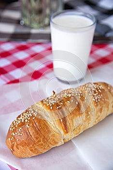 Beef wiener sesame croissant served with a glass of yogurt photo