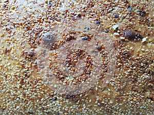 Home made bread, a surface with a lot of susam seeds, landscape orientation.