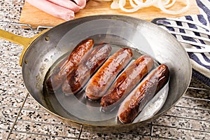 Home made british sausages in a brass pan