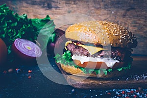 Home made Burger cheeseburger with beef on a wooden background. Classic home made Burger. Close up, copy space