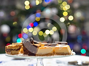 Home made cake on the plate. Bokeh christmas tree lights background