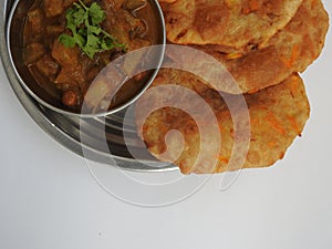 Home made Carrot Puri or Poori with Vegetable Curry in a cup with big plate isolated on white background